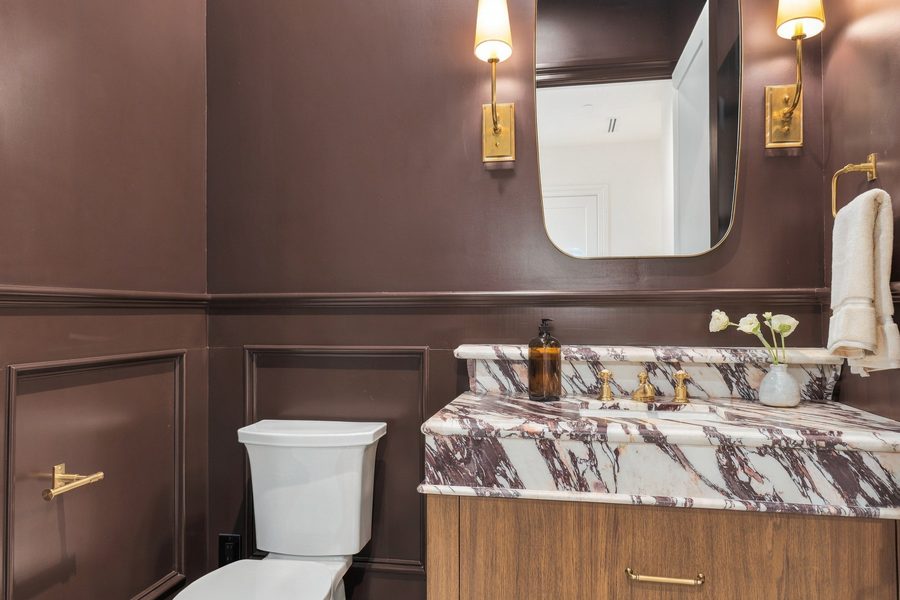 Powder room with dark plum walls and a purple-veined marble vanity