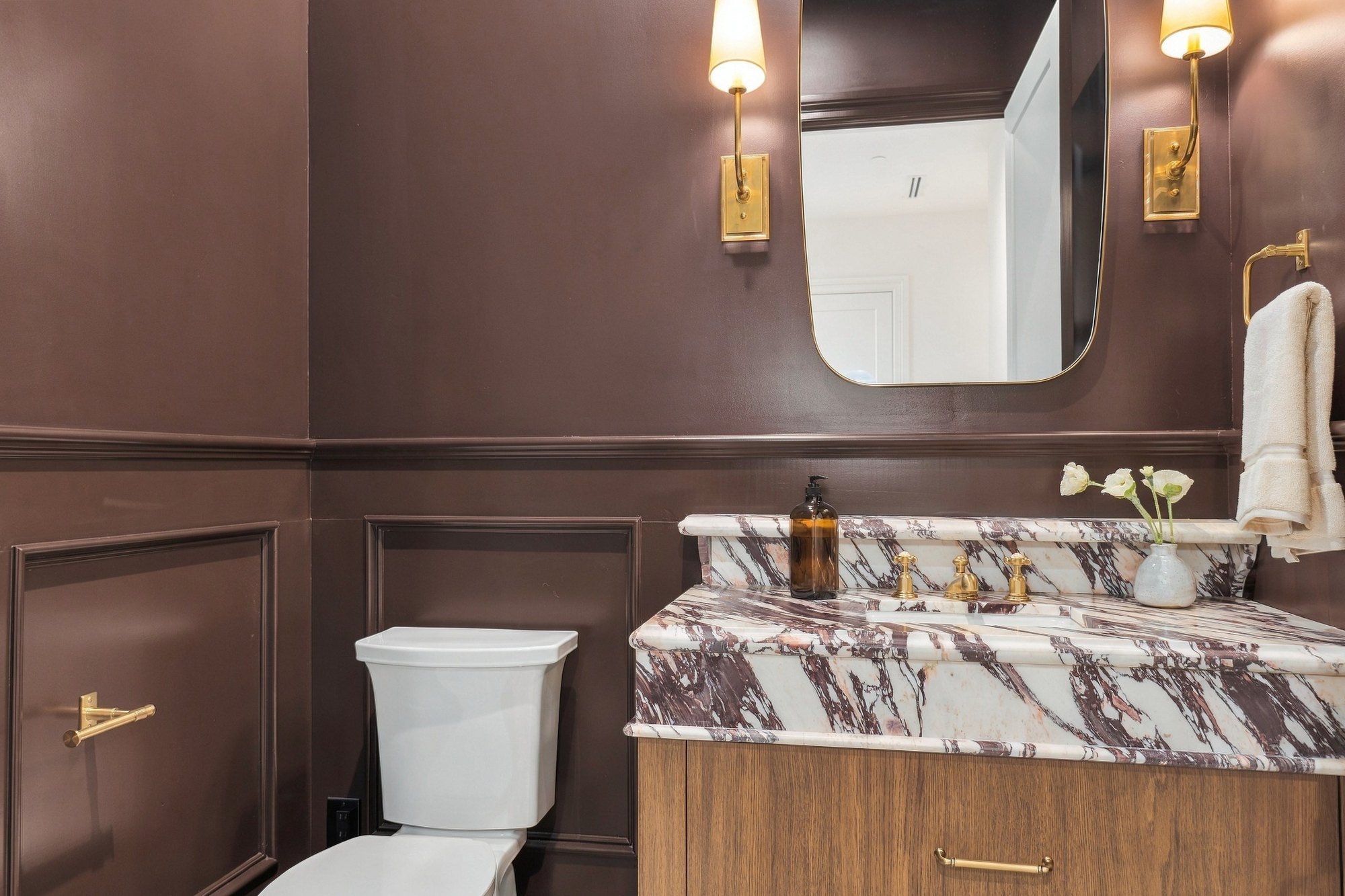 Powder room with dark plum walls and a purple-veined marble vanity