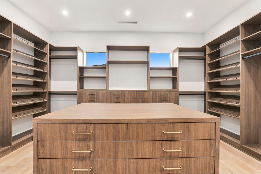 Walk-in closet with walnut shelving and a center island